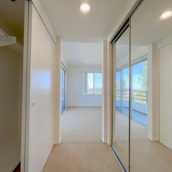 Thumbnail 49 of 53 A hallway with white walls and a carpeted floor.