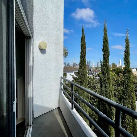 Thumbnail 44 of 53 A balcony with a metal railing and a view of a city skyline.