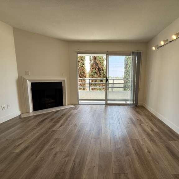 Thumbnail 11 of 13 A room with a fireplace and sliding glass doors.