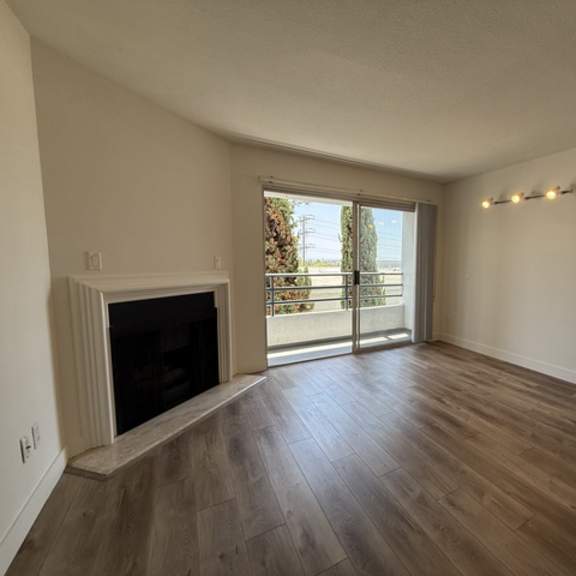 Thumbnail 13 of 13 A living room with a fireplace and sliding glass doors.
