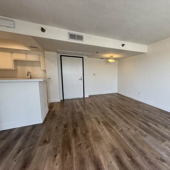 Thumbnail 7 of 13 A room with wooden flooring and a white door.