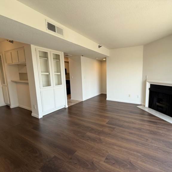 Thumbnail 17 of 31 A living room with a fireplace and wood flooring.