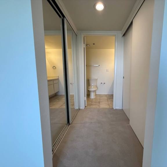 Thumbnail 31 of 31 A hallway with a toilet visible through the door.