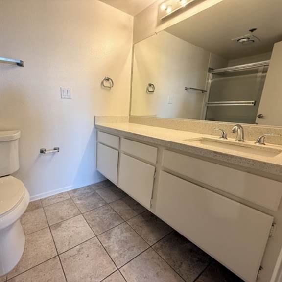 Thumbnail 25 of 31 A white toilet sits in a bathroom next to a sink.