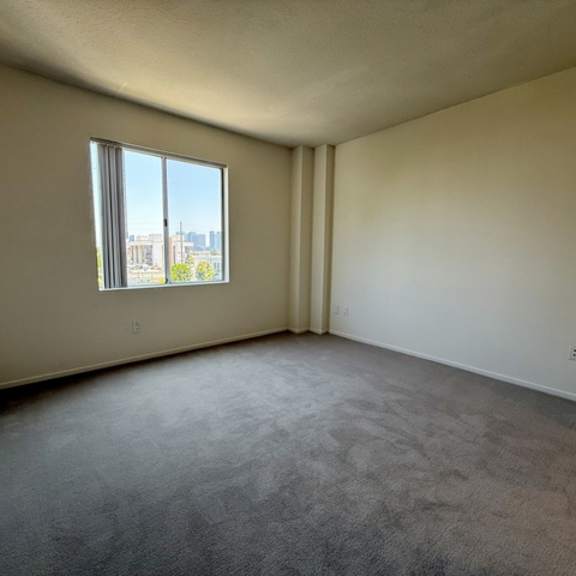 Thumbnail 24 of 31 Empty room with a window and a view of the city.