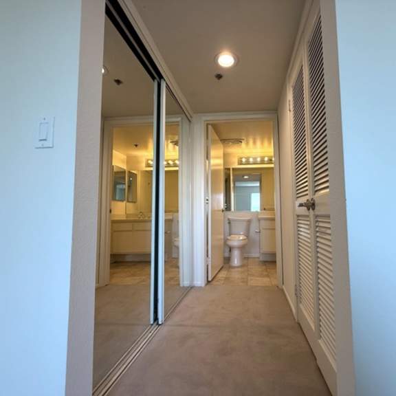 Thumbnail 22 of 31 A bathroom with a toilet and sink is visible through a glass door.