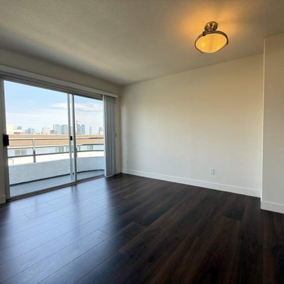 Thumbnail 24 of 28 A room with a sliding glass door leading to a balcony.