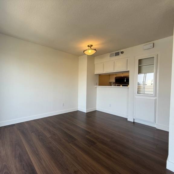 Thumbnail 21 of 28 A room with wooden floors and white walls.