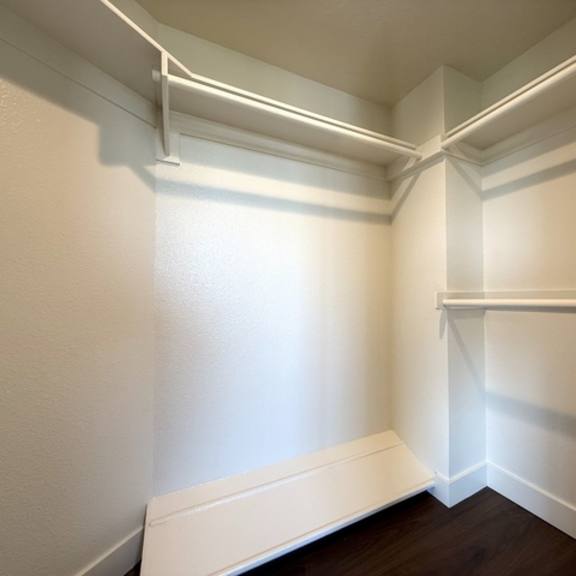 Thumbnail 27 of 28 A white closet with a white bench at the bottom.