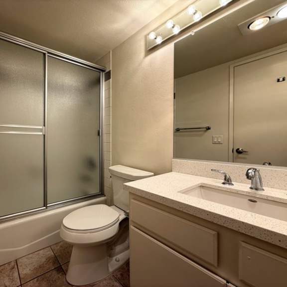 Thumbnail 13 of 28 A bathroom with a toilet, sink, and shower.