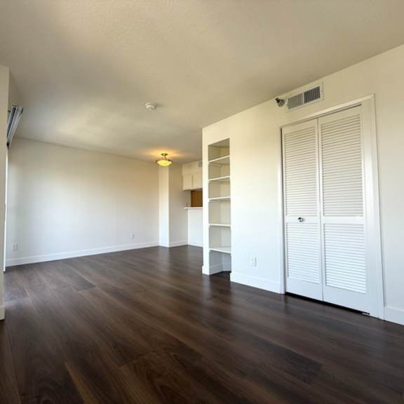 Thumbnail 22 of 28 A room with wooden floors and white walls.