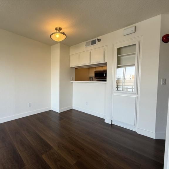 Thumbnail 15 of 28 A room with wooden floors and white walls.