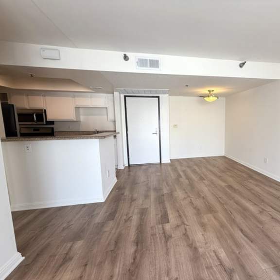 Thumbnail 3 of 18 A room with a white door and a wooden floor.