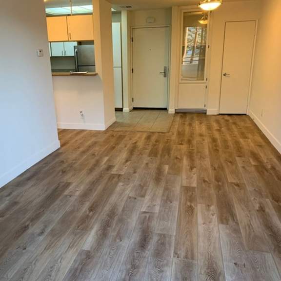 Thumbnail 4 of 8 A room with wooden flooring and white walls.