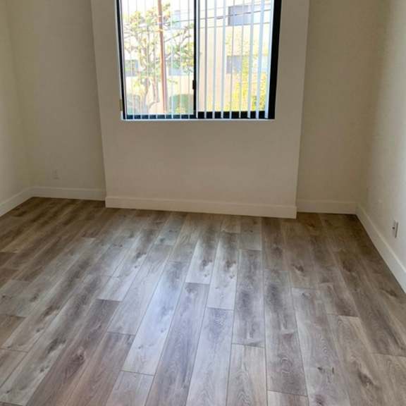 Thumbnail 8 of 8 A room with wooden flooring and a window with blinds.