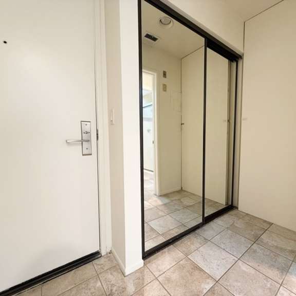 Thumbnail 7 of 13 A white door with a glass panel is open to a hallway.
