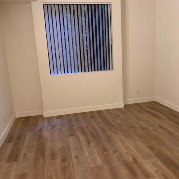 Thumbnail 7 of 7 A room with wooden flooring and a window with blinds.