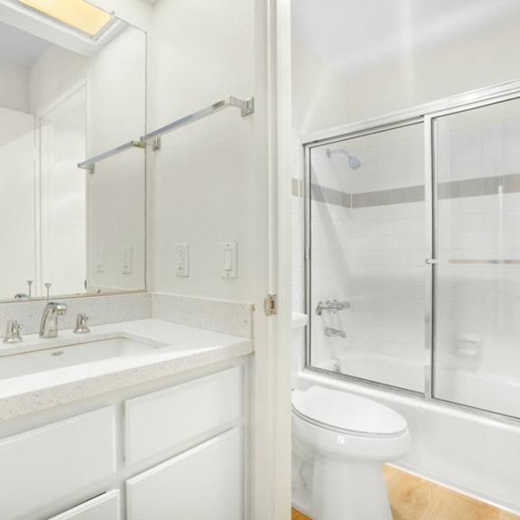 Thumbnail 14 of 26 A white bathroom with a sink, toilet, and shower.