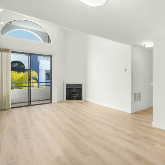 Thumbnail 8 of 26 A modern kitchen with wooden floors and white walls.