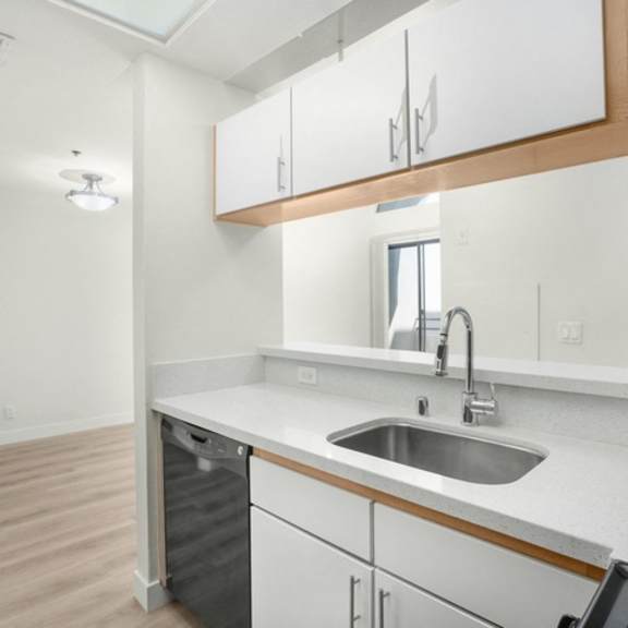 Thumbnail 11 of 26 A kitchen with white cabinets and a wooden counter.