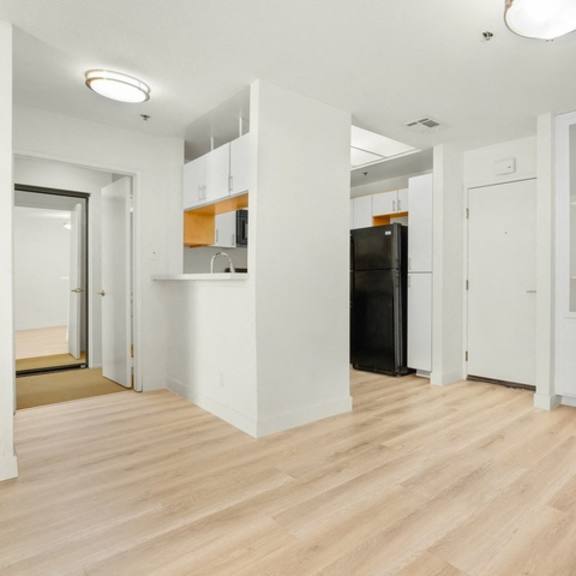Thumbnail 20 of 26 A kitchen area with a black fridge and white cabinets.