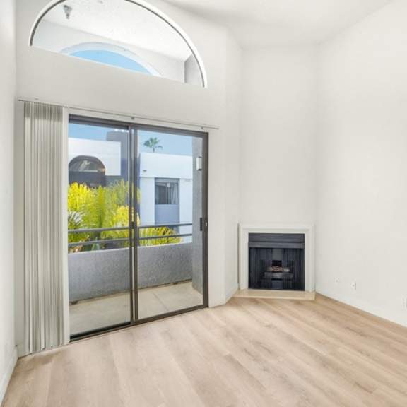 Thumbnail 12 of 26 A room with a fireplace and a sliding glass door.