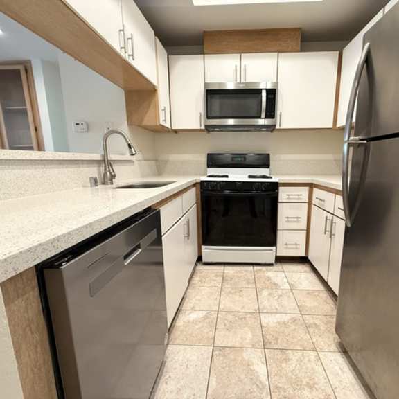 Thumbnail 16 of 44 A kitchen with a stainless steel refrigerator, dishwasher, and oven.