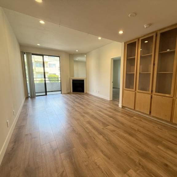 Thumbnail 17 of 44 A room with wooden flooring and a large window.