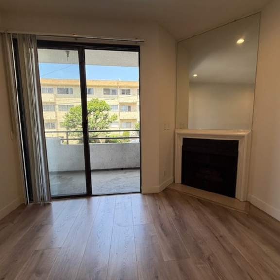 Thumbnail 7 of 44 A room with a fireplace and sliding glass doors.