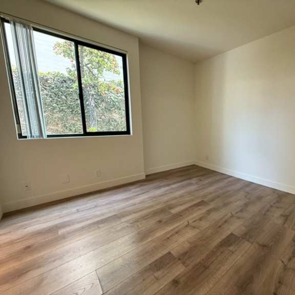 Thumbnail 9 of 44 A room with wooden flooring and a window.