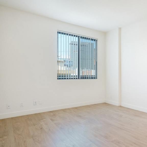 Thumbnail 5 of 7 Empty room with a window and wooden floor.