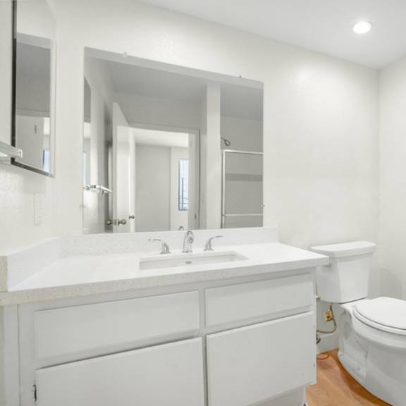 Thumbnail 15 of 39 A white bathroom with a toilet and sink.