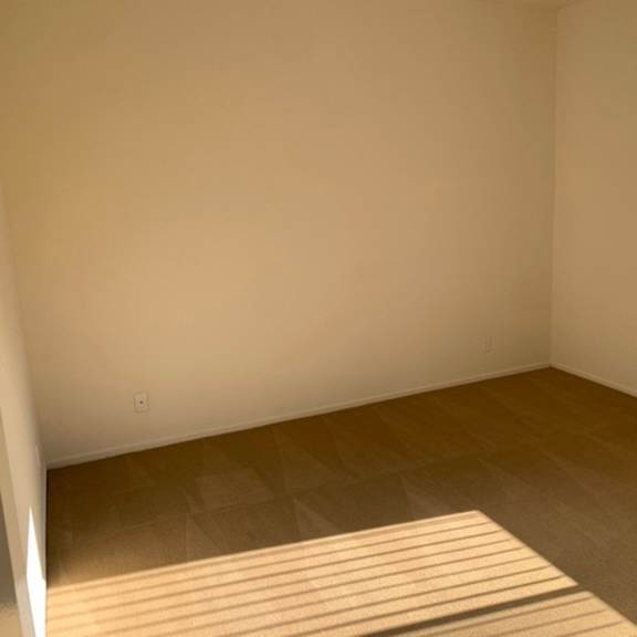 Thumbnail 15 of 30 A room with a window on the right side and a wooden floor.