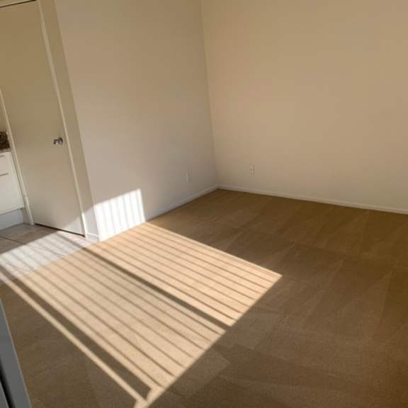 Thumbnail 9 of 30 A room with a tan carpet and white walls.