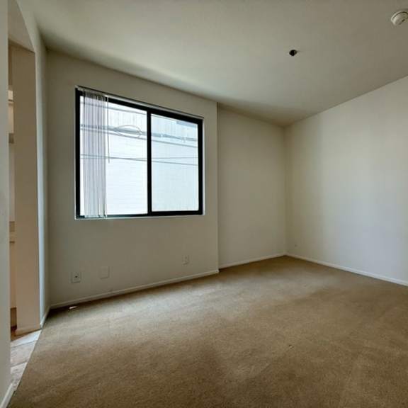 Thumbnail 41 of 44 A room with a window and carpeted floor.