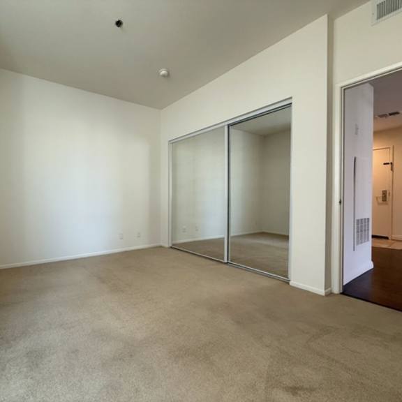 Thumbnail 37 of 44 A large empty room with a carpeted floor and white walls.