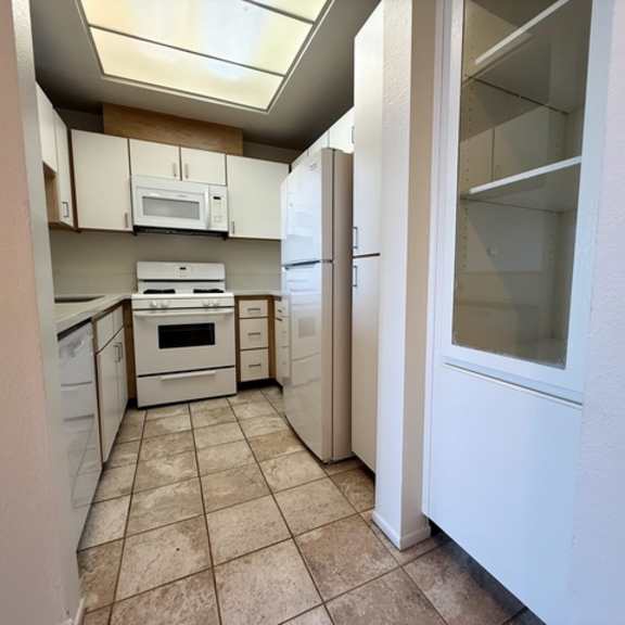 Thumbnail 6 of 54 A kitchen with white appliances and cabinets.