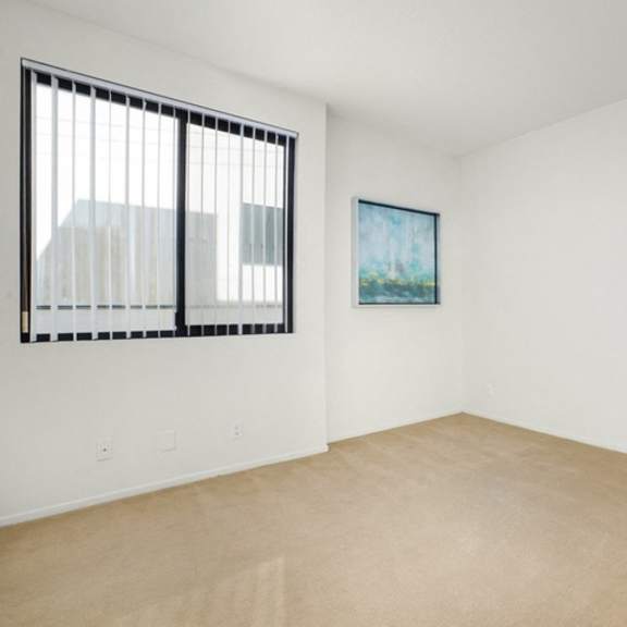 Thumbnail 40 of 44 A room with a painting on the wall and a window with blinds.