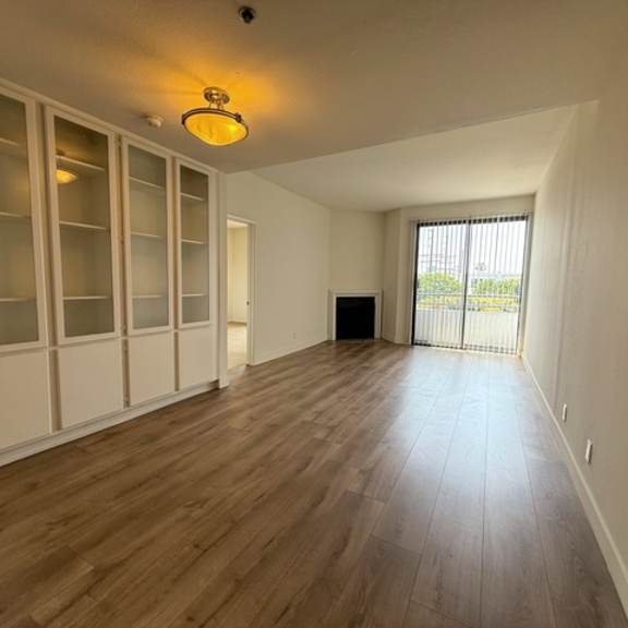 Thumbnail 4 of 39 A room with wooden floors and a large window.