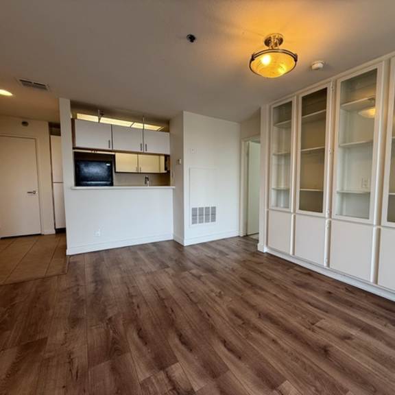 Thumbnail 33 of 39 A room with a wooden floor and white walls.