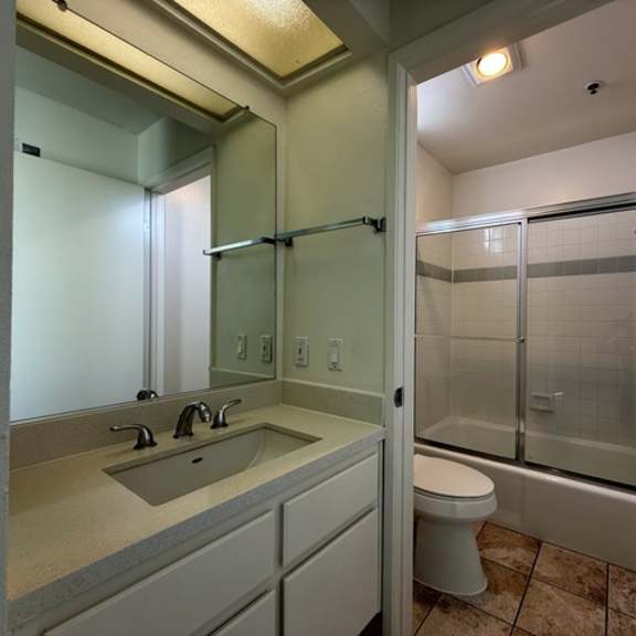 Thumbnail 31 of 39 A bathroom with a sink, toilet, and shower.