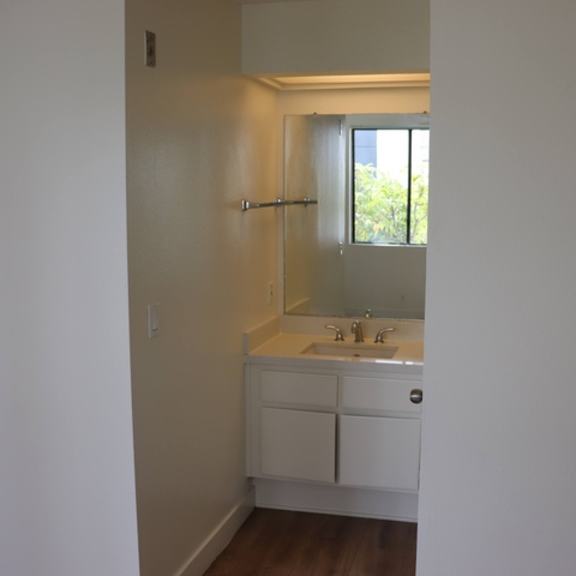 Thumbnail 27 of 30 A small white bathroom with a sink and mirror.