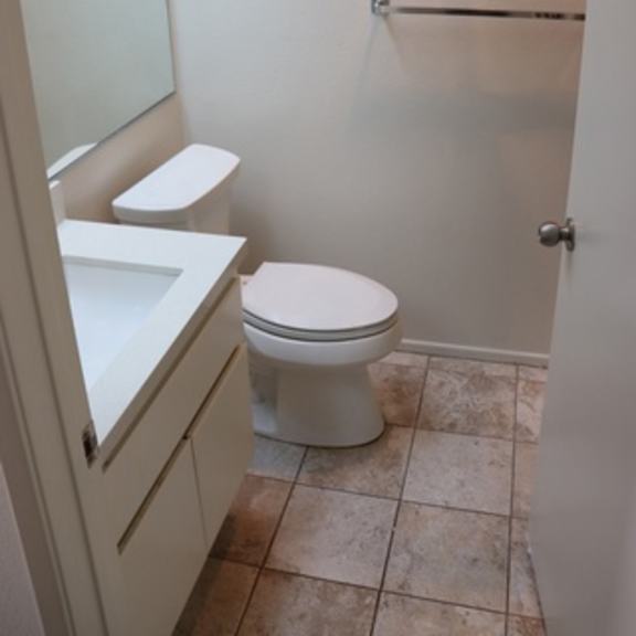 Thumbnail 29 of 30 A white toilet sits in a bathroom next to a sink.