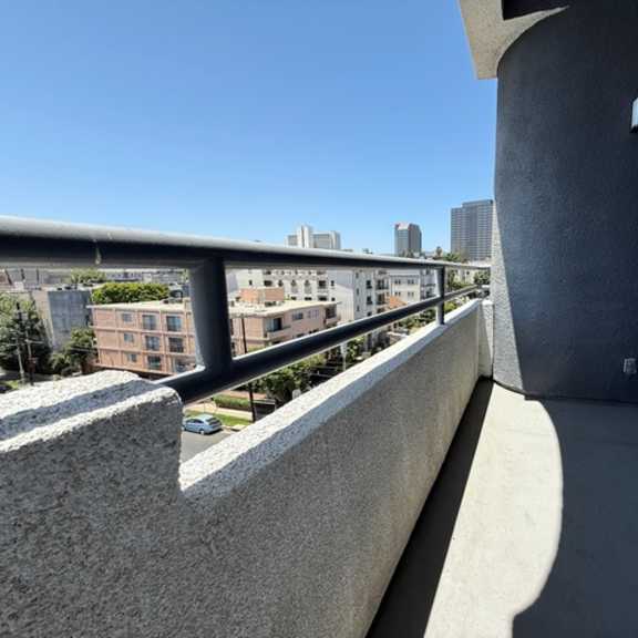 Thumbnail 44 of 54 A balcony with a metal railing overlooking a cityscape.