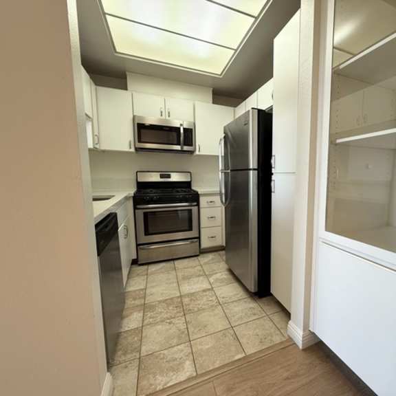 Thumbnail 45 of 54 A kitchen with a refrigerator, oven, and microwave.