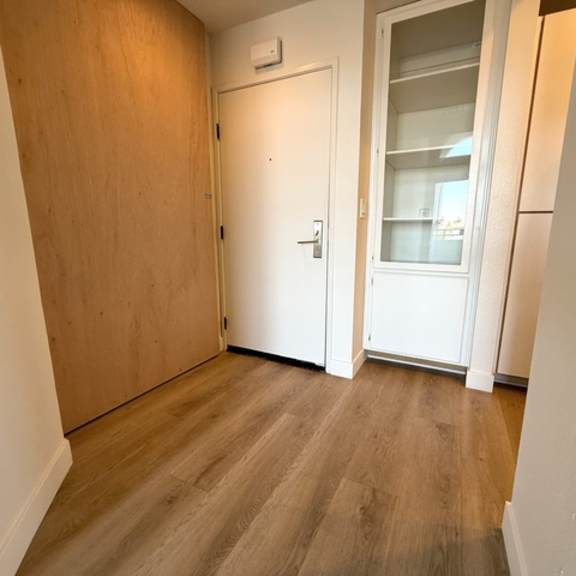 Thumbnail 10 of 22 A room with a white door and a window with a white frame.