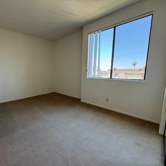 Thumbnail 7 of 22 Empty room with a window overlooking a building.