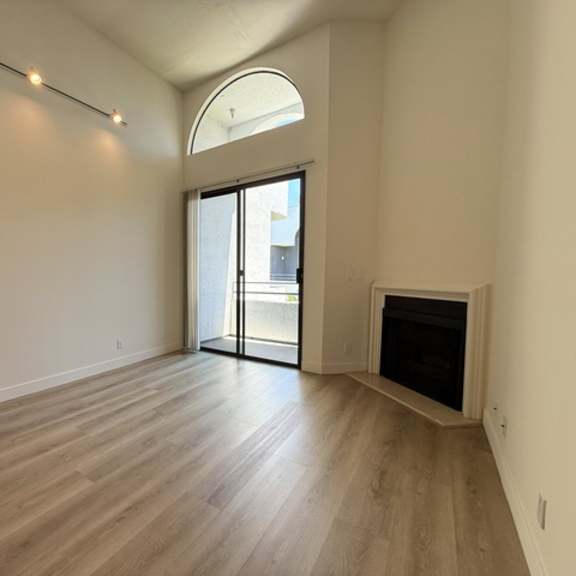 Thumbnail 21 of 26 A room with a fireplace and sliding glass doors.