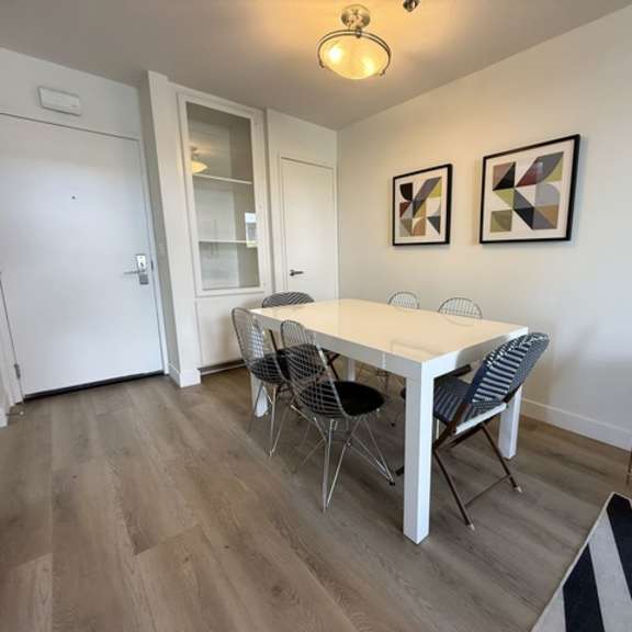 Thumbnail 5 of 27 A dining room with a white table and chairs.