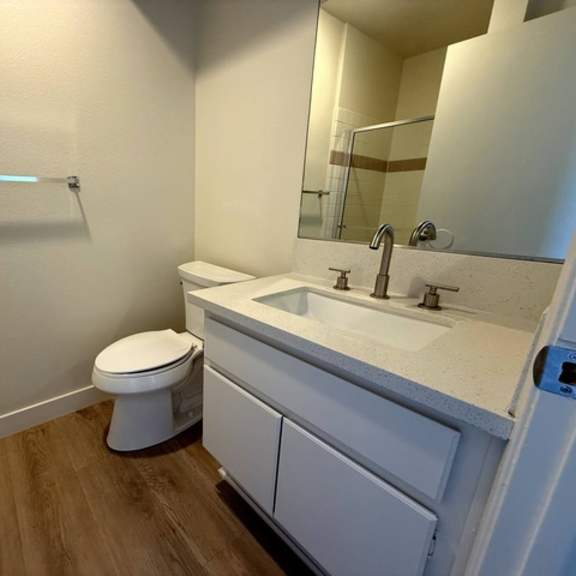 Thumbnail 12 of 27 A white toilet sits in a bathroom next to a sink.